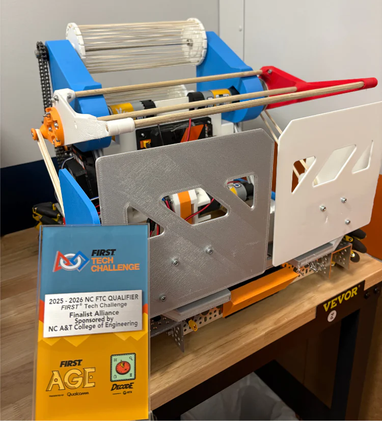 A colorful FIRST Tech Challenge robot with a roller mechanism stands next to its Finalist Alliance award plaque. TITLE
