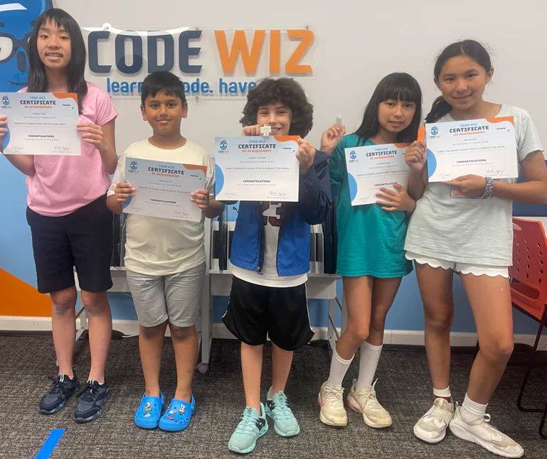 Five happy children proudly display their Code Wiz certificates of achievement.
