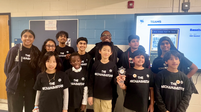 Smiling students and their mentor from 'The Mechanavators' team celebrate with a star