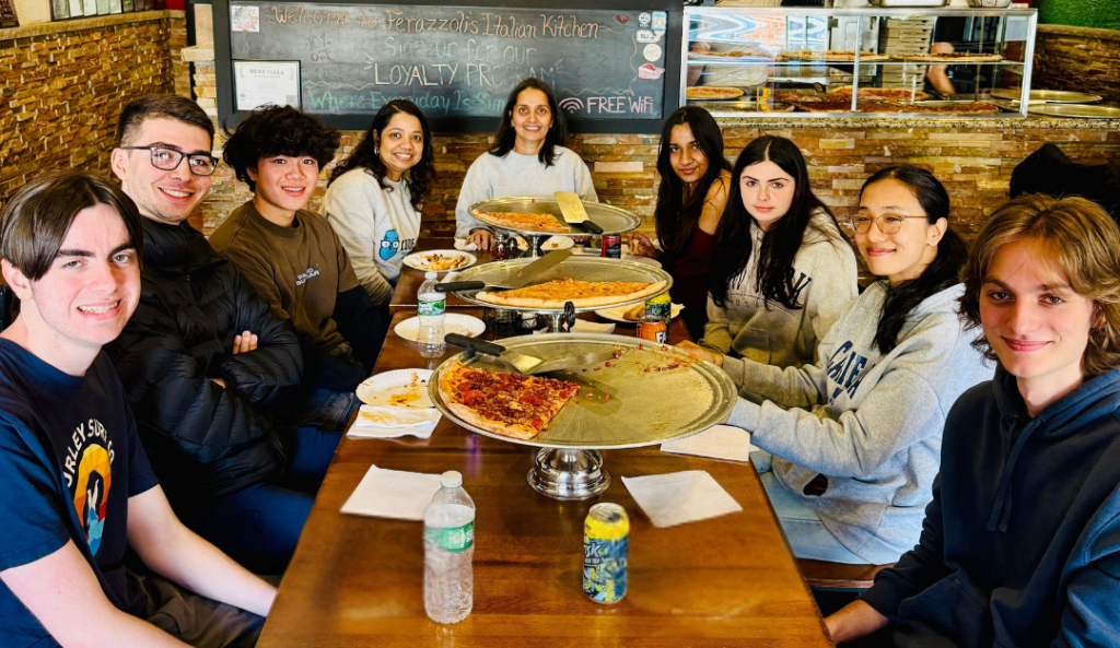 Smiling friends enjoy pizza and drinks at Ferazzoli's Italian Kitchen.