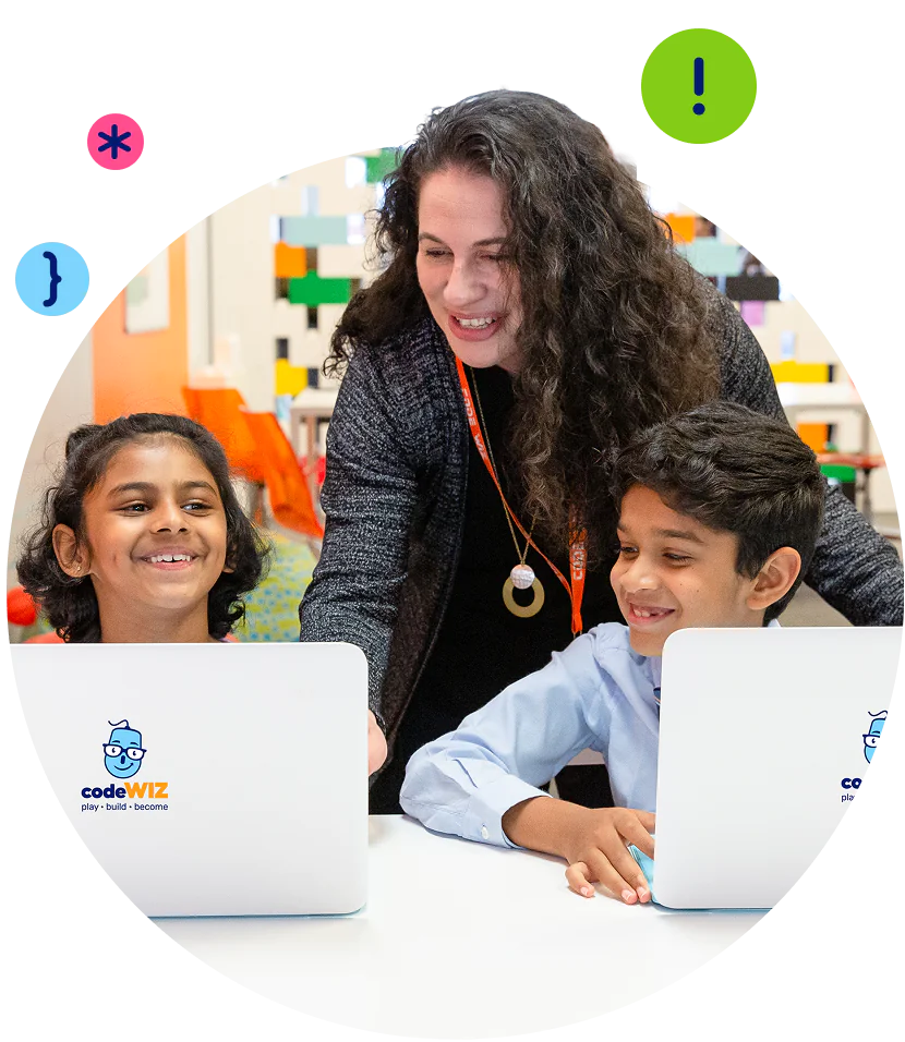 A smiling instructor helps two happy children learn coding on codeWIZ laptops.