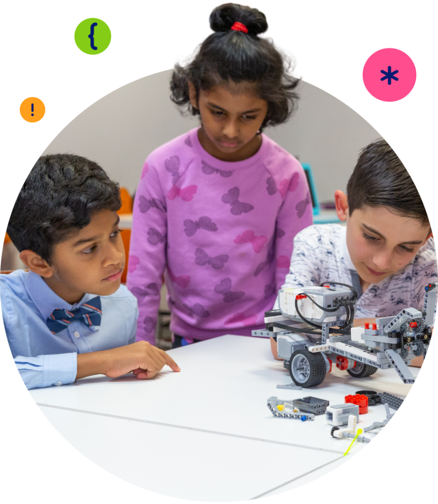 Three children intently build and examine a robot made from LEGO-like parts on a white table.